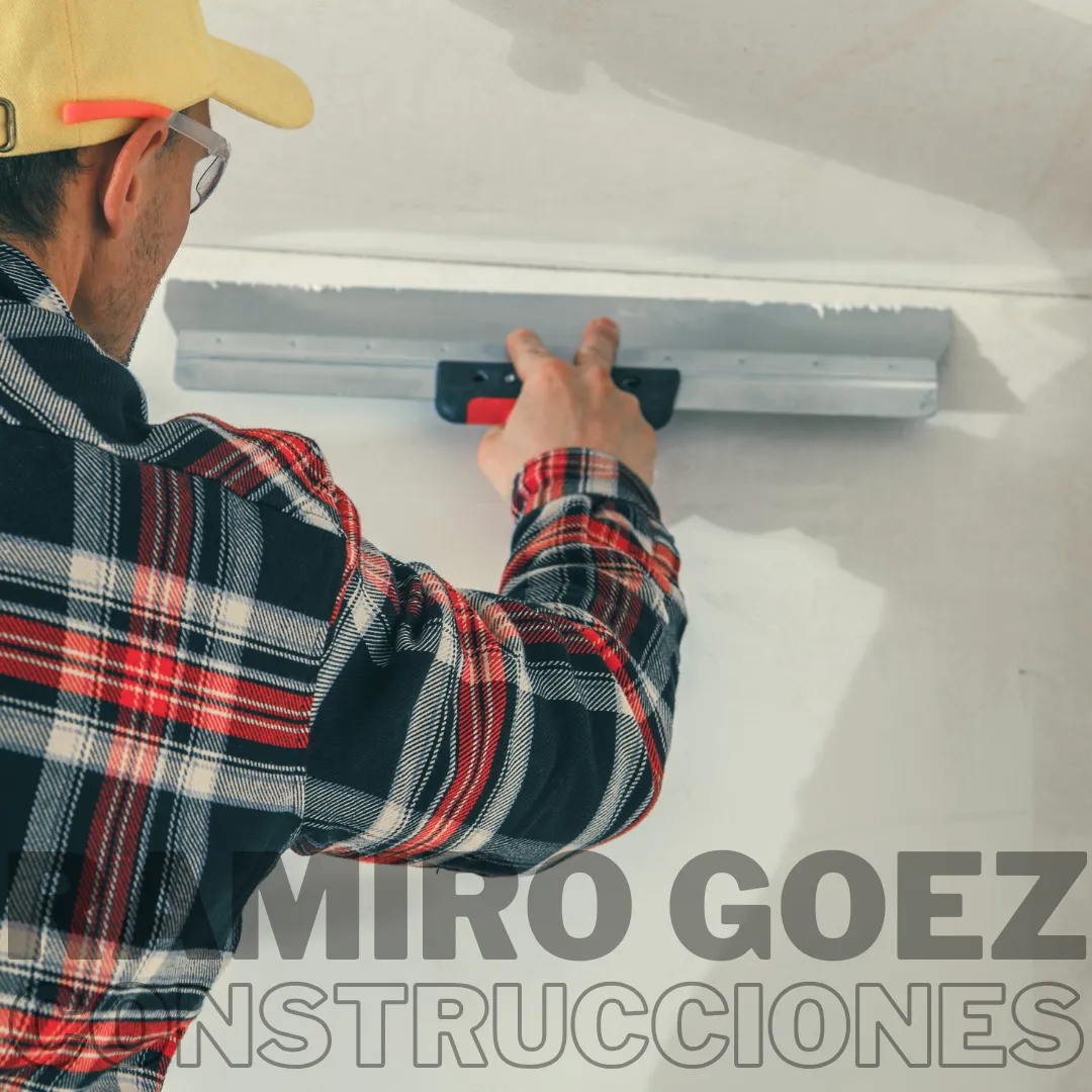 Ramiro Goez aplicando estuco con llana en una pared en Medellín