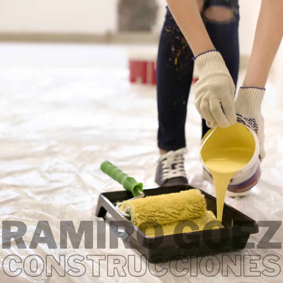 Ramiro Goez pintando una pared en un apartamento en Medellín