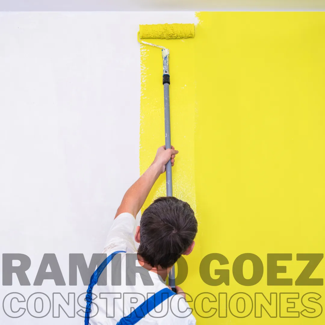 Ramiro Goez aplicando pintura en una pared en obra en Medellín