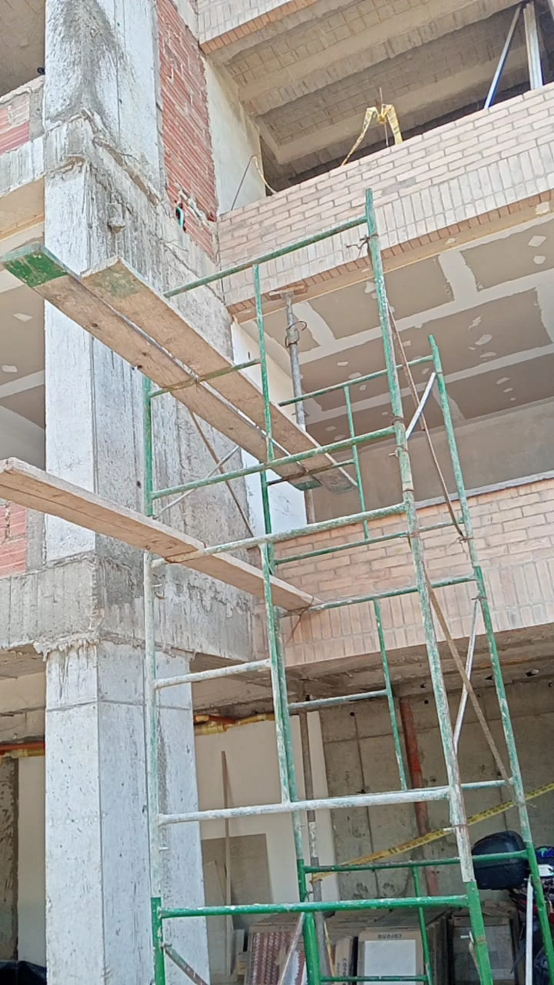 Fachada de un edificio en obra, con andamios y cielos en drywall - Acabados de Apartamentos VIS en Medellín - Ramiro Goez Construcciones