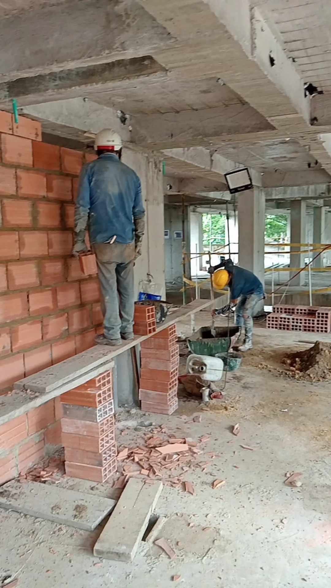 Levante del muro: el maestro pega el bloque y el ayudante mezcla el mortero - Mampostería en Medellín - Ramiro Goez Construcciones